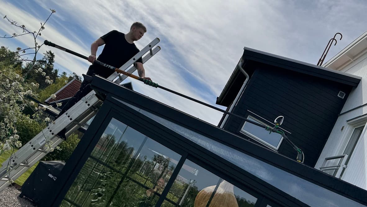 Närbild på rengöring av uterumstak med kolfiberstång och ultrarent vatten